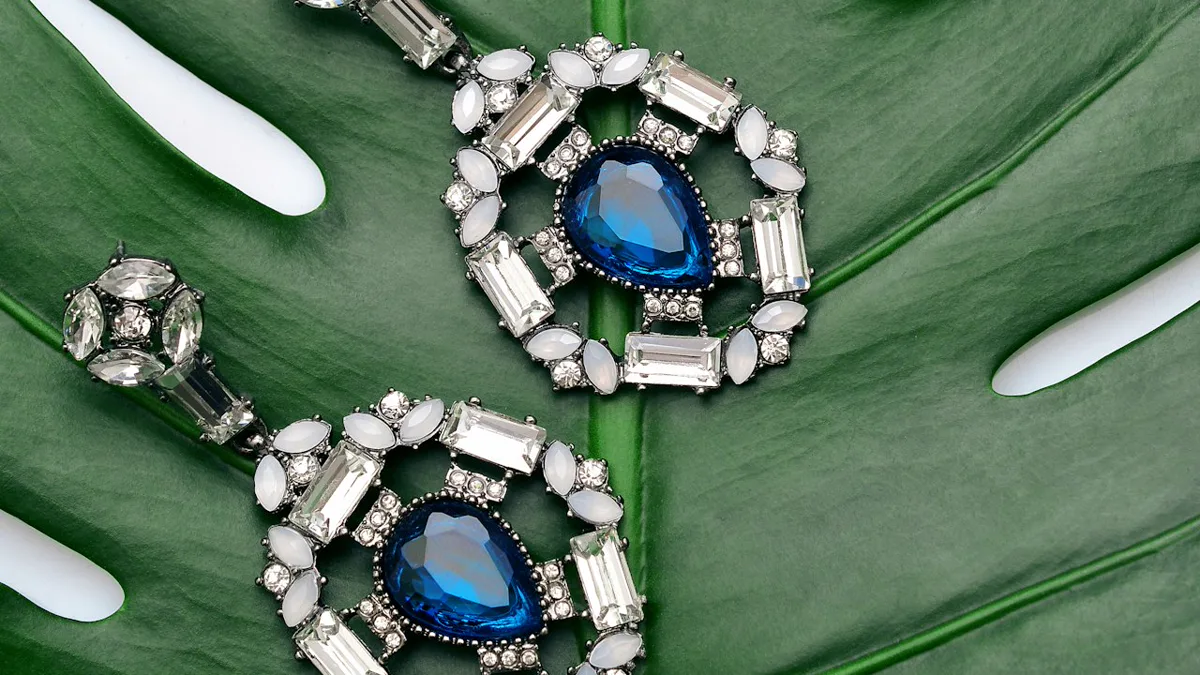 how to price handmade jewelry: detailed jewelry making supplies, wire, pliers, and gemstones on wooden desk